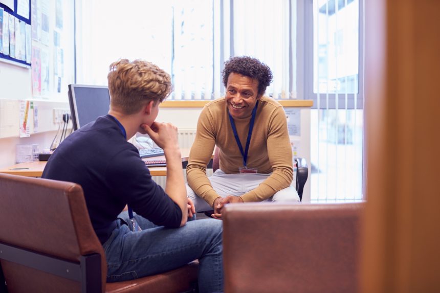 A teenage boy speaking to a student counsellor on Results Day.