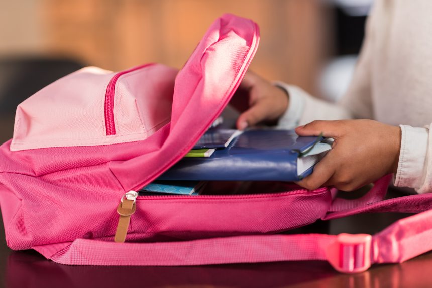 A girl packing her backpack the night before an exam.