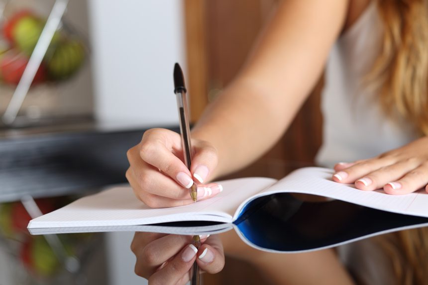 Student writing in a notebook.