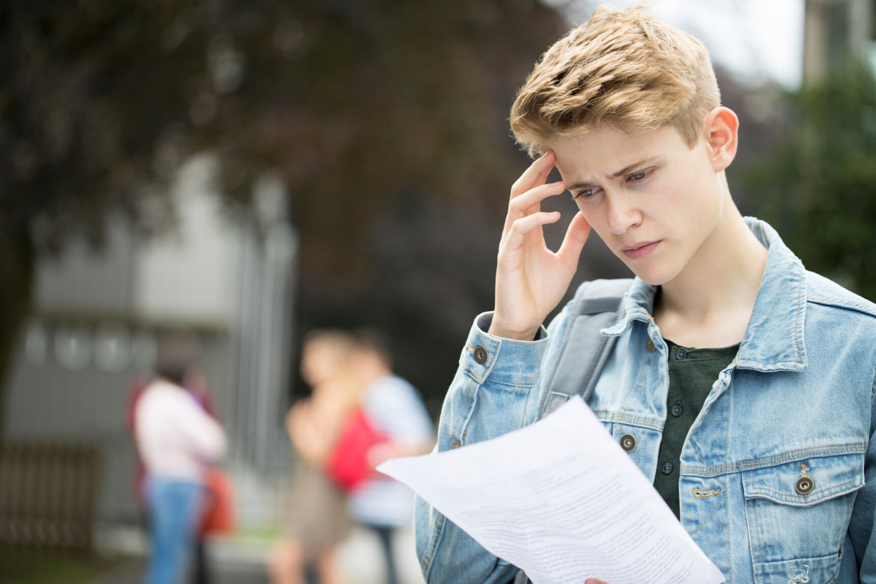 A teenage boy looks worried and disappointed as he looks at his results slip on GCSE Results Day 2026.