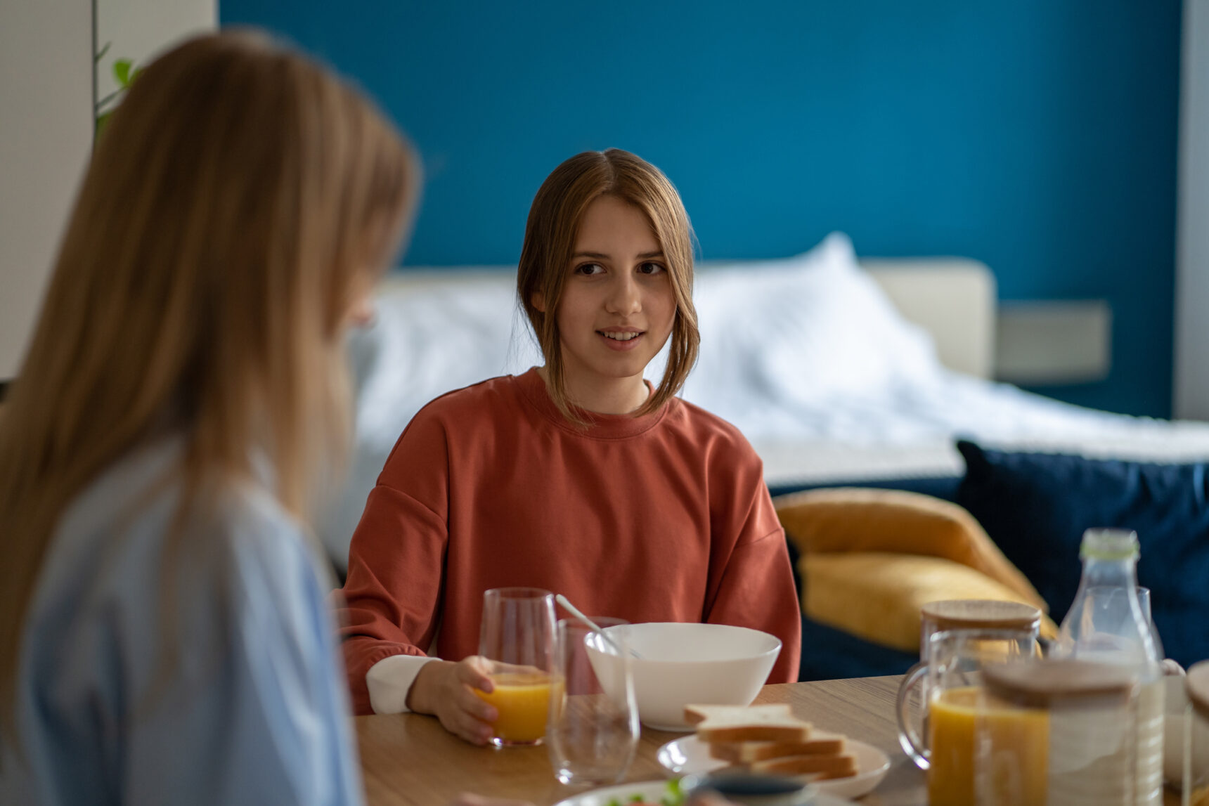 A teenage girl is having breakfast with her mother on GCSE Results Day 2026.