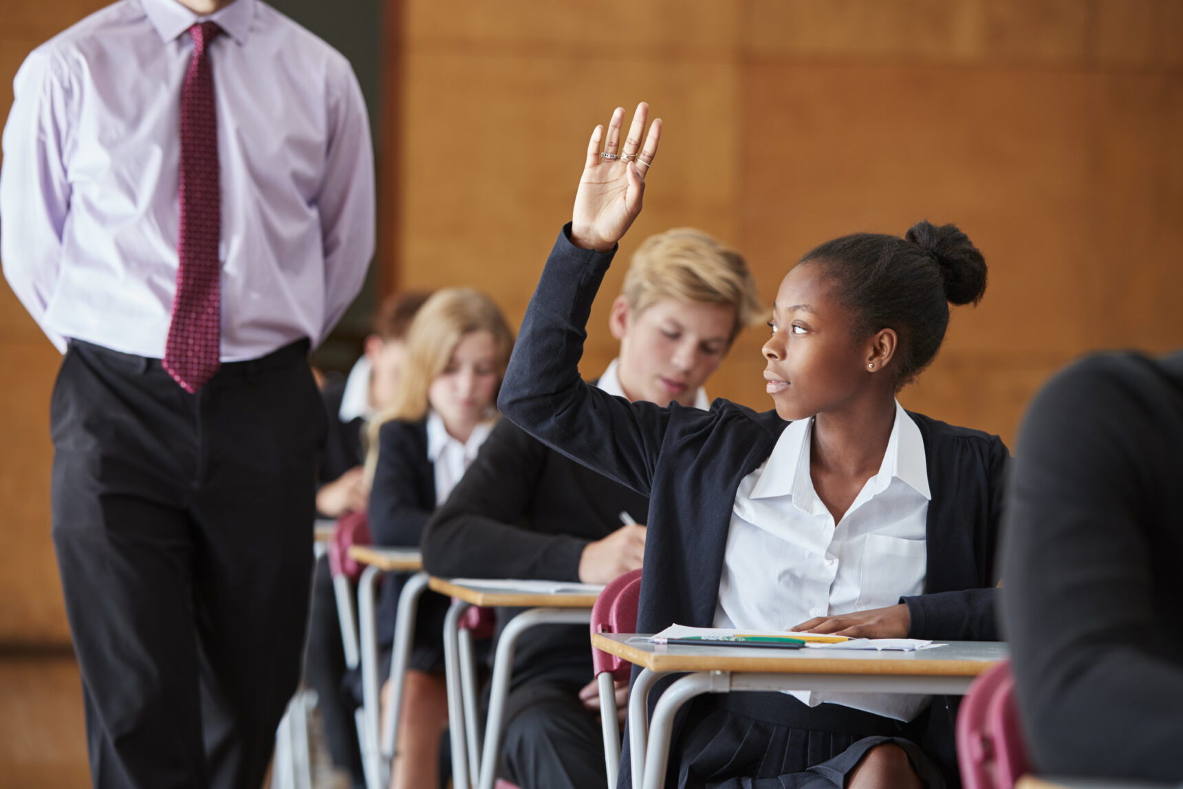 A female student is asking a question during a GCSE mock exam.