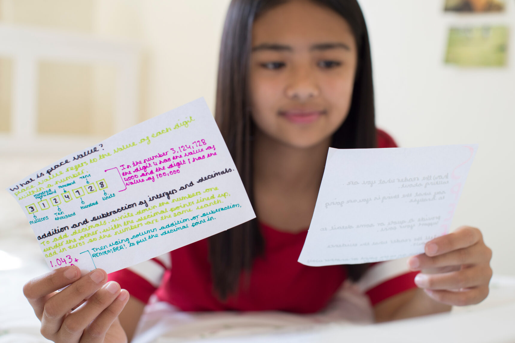 A female student is studying for an exam using flashcards.
