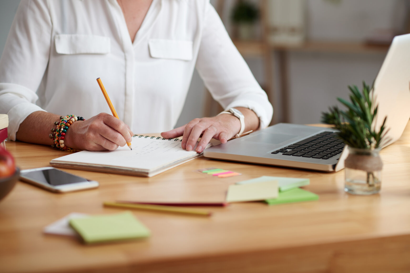 An online tutor is sitting at a desk calculating their earnings once the tutoring platform's fees have been decucted.