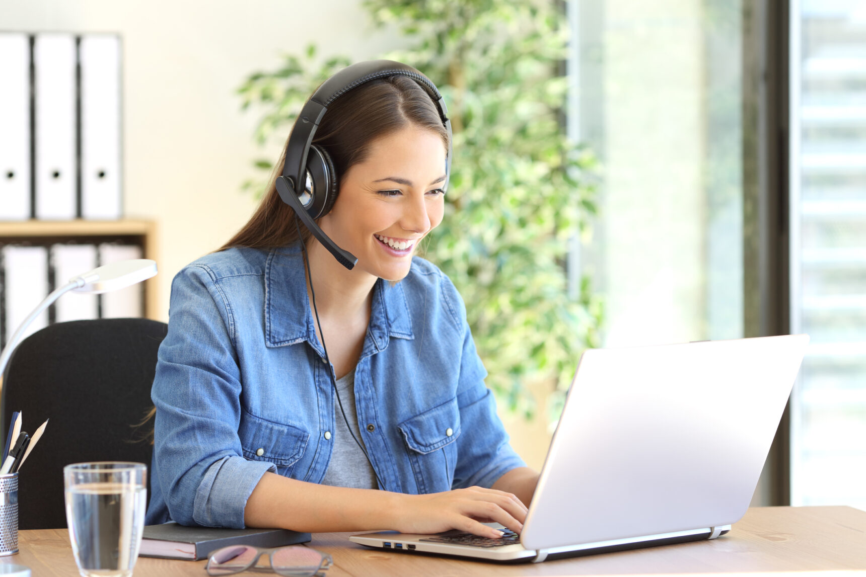 A female online tutor is smiling as she tutors a student.