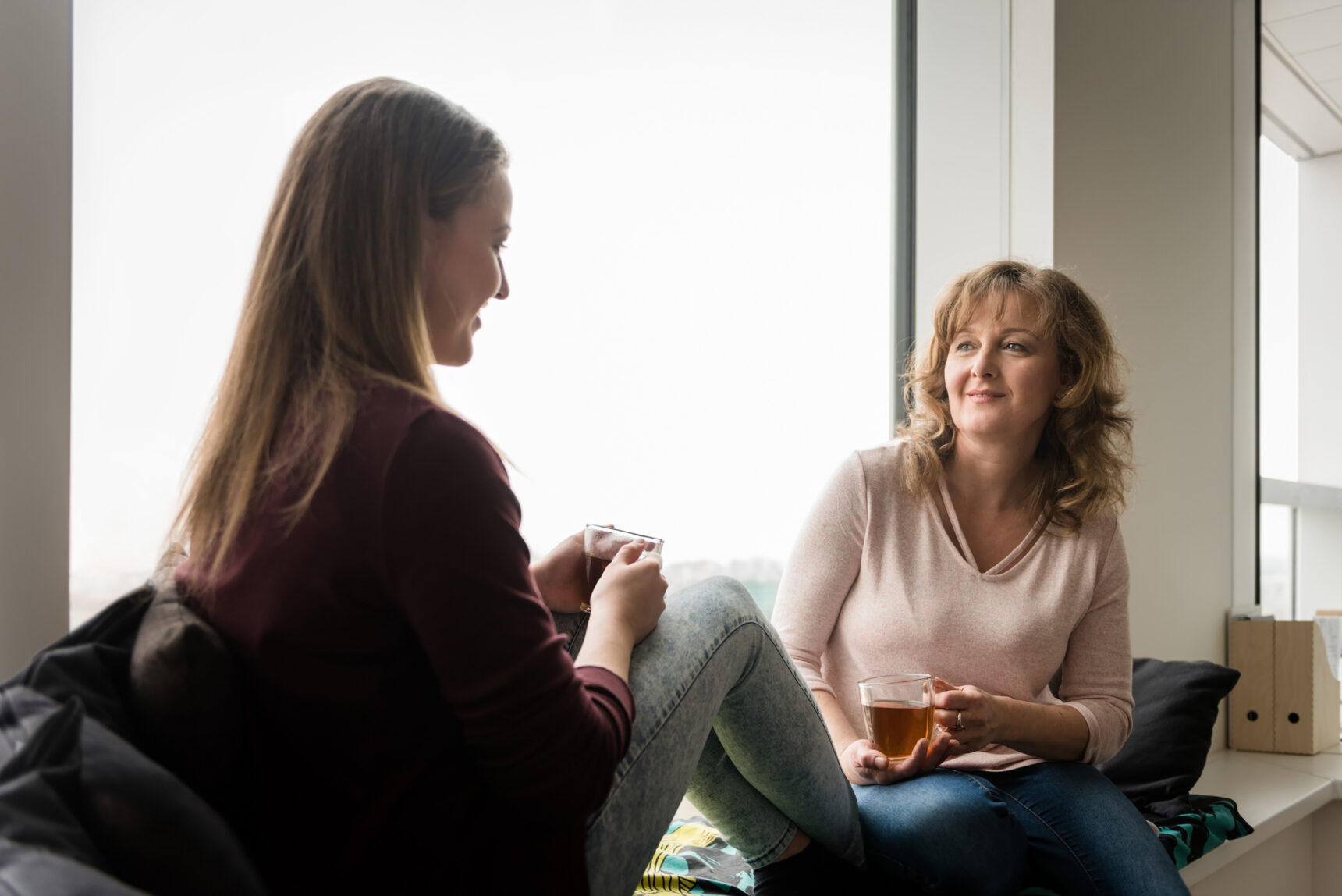 Mother and daugther drinking tea and chatting about GCSE exam revision.