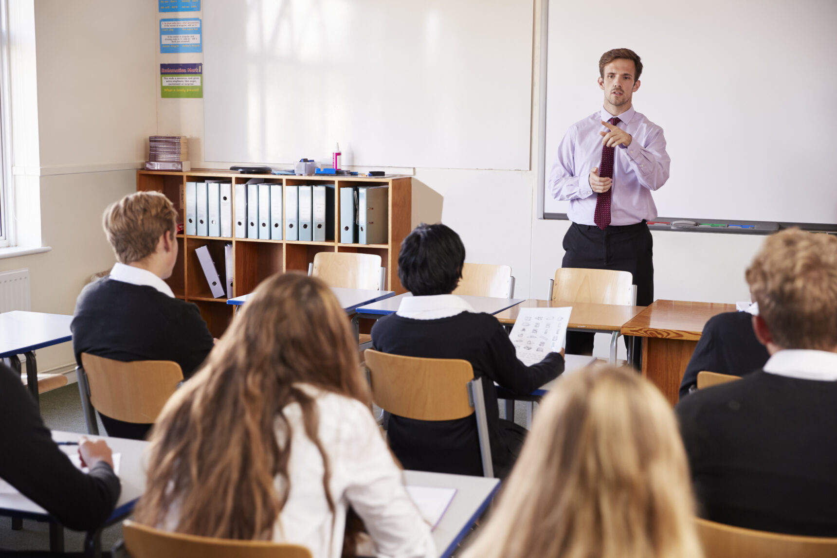 Male teacher using cold call method during an English lesson.